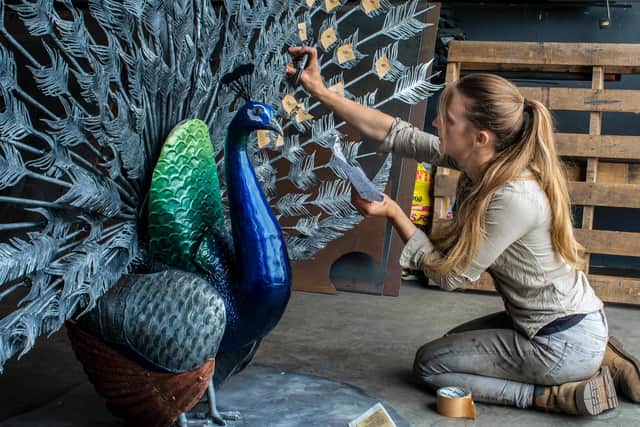 Katie Ventress puts the finishing touches to the peacock. Picture: Ernesto Rogata.