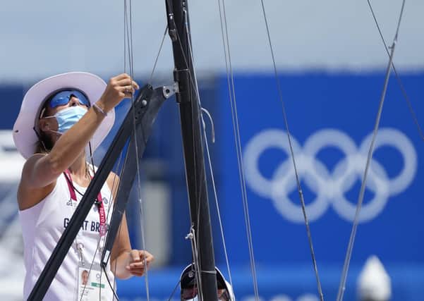 Becalmed: Britain's Charlotte Dobson checks her boat ahead of the women's 49er medal race at the Enoshima Yacht harbour. All the sailing events were postponed due to the lack of wind.