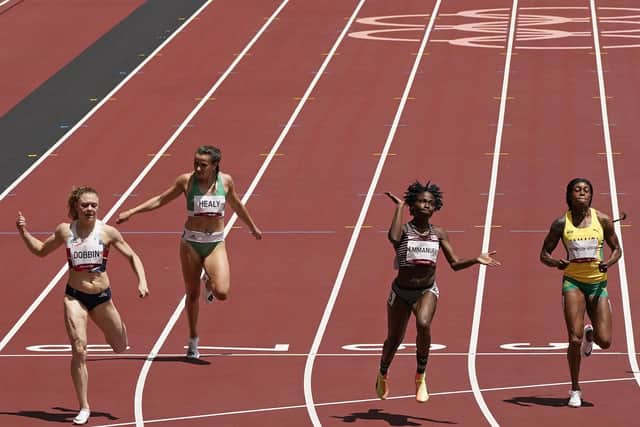 Beth Dobbin, of Britain, Phil Healy, of Ireland, Crystal Emmanuel, of Canada, Elaine Thompson-Herah, of Jamaica and Imke Vervaet, of Belgium, from left, cross the line in a women's 200m first round heat at the 2020 Summer Olympics. (AP Photo/Charlie Riedel)