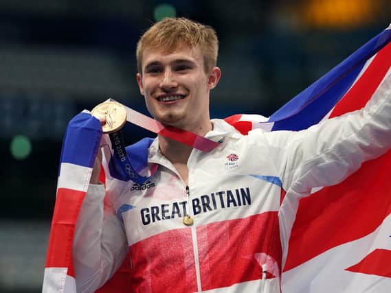 Great Britain's Jack Laugher celebrates on the podium with the bronze medal for the Men's 3m Springboard