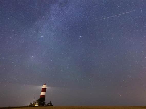 A meteor during the Perseid meteor shower seen over Happisburgh lighthouse, Norfolk  Pic: Joe Giddens/PA Wire