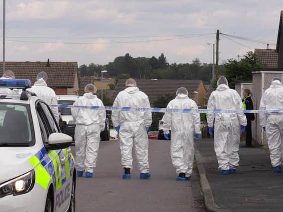 Forensic officers comb the scene at Whinmoor, Leeds, after a murder investigation is launched into the death of Eileen Barrott