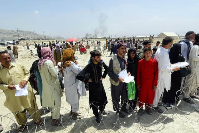 Hundreds of people gather outside the international airport in Kabul, Afghanistan, Tuesday, Aug. 17, 2021. The Taliban declared an "amnesty" across Afghanistan and urged women to join their government Tuesday, seeking to convince a wary population that they have changed a day after deadly chaos gripped the main airport as desperate crowds tried to flee the country. (AP Photo).