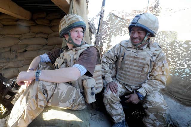 Prince Harry (L) talks to a Gurkha January 02, 2008, after firing a 50mm machine gun at Taliban fighters in Helmand province in Southern Afghanistan. (Credit: John Stillwell/AFP via Getty Images)
