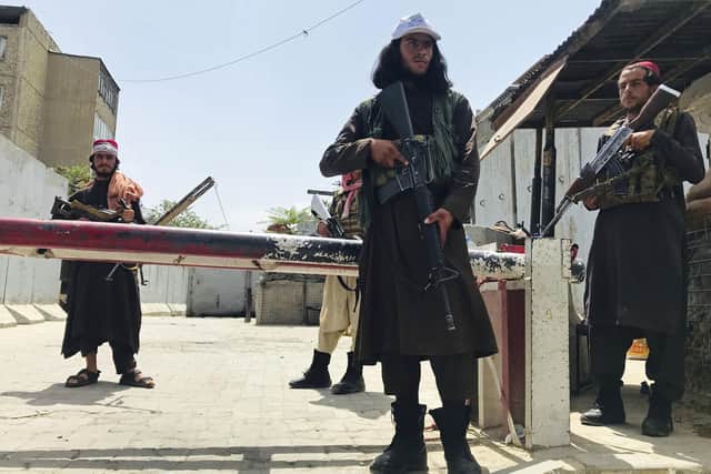 Taliban fighters stand guard at a checkpoint near the US embassy that was previously manned by American troops, in Kabul, Afghanistan.