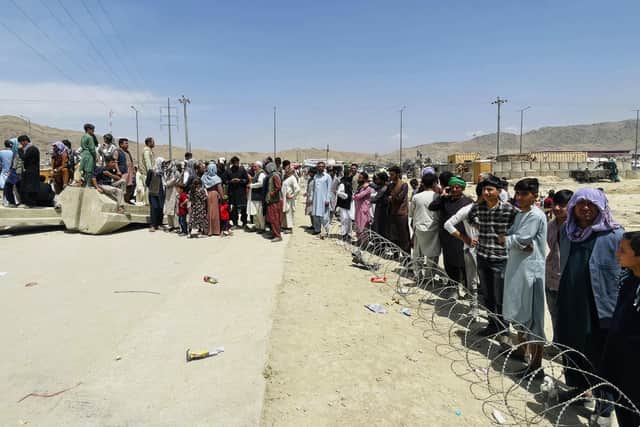 Hundreds of people gather outside the international airport in Kabul, Afghanistan, hoping to flee the Taliban.