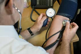 File photo dated 10/09/14 of a GP checking a patient's blood pressure. (PA/Anthony Devlin)