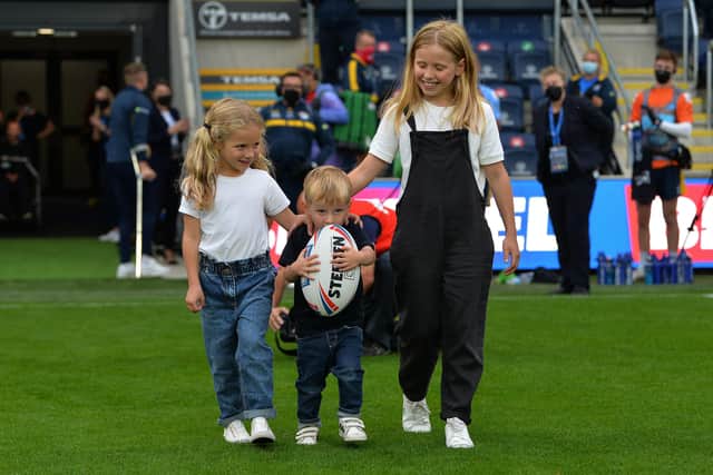 Rob Burrow's children, Macy, Maya and Jackson bring out the match ball.  Picture: Jonathan Gawthorpe