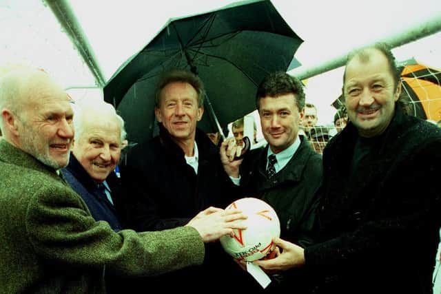 Former Huddersfield Town players: From left, Ray Wilson, Vic Metcalfe , Denis Law, Trevor Cherry and Frank Worthington  holding the ball used in the last game at Leeds Road and above a plaque on the exact centre spot of the old Leeds Road ground.