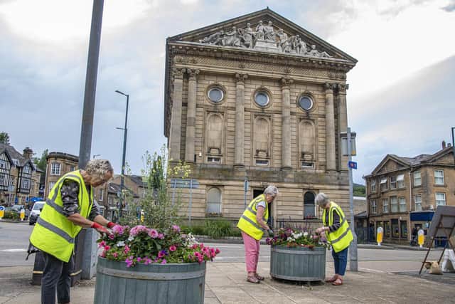 Volunteers from Todmorden in Bloom tend to the floral displays outside Todmorden town hall.  Picture by Tony Johnson