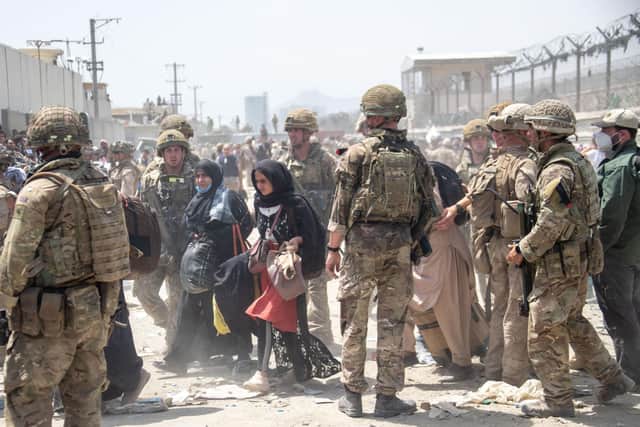 Handout photo dated 20/08/21 issued by the Ministry of Defence (MoD) of members of the British (left) and US military engaged in the evacuation of people out of Kabul, Afghanistan.