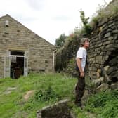 Ivan Beardsell beside the crumbling drystone wall in Holmfirth