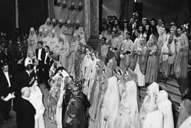 The Queen (bottom left, wearing a crown) and Prince Philip talk to the cast after a performance of Samson by the Covent Garden Opera Company, at the Grand Theatre, Leeds, circa 1952. (Photo: Getty Images).