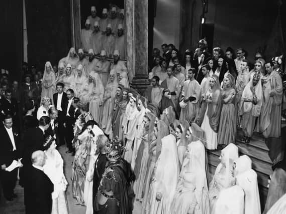 The Queen (bottom left, wearing a crown) and Prince Philip talk to the cast after a performance of Samson by the Covent Garden Opera Company, at the Grand Theatre, Leeds, circa 1952. (Photo: Getty Images).