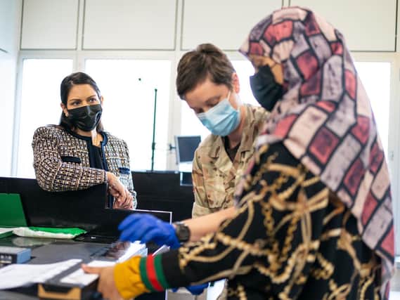 Home Secretary Priti Patel watches as a refugee has her fingerprints taken after arriving from Afghanistan on a evacuation flight at Heathrow Airport, London. Picture date: Thursday August 26, 2021. Picture: Dominic Lipinski/PA Wire