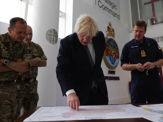Prime Minister Boris Johnson with Vice Admiral Ben Key (right) as he looks at a map of the Afghanistan region during a visit to Northwood Headquarters, the British Armed Forces Permanent Joint Headquarters, in Eastbury, north west London (PA/Adrian Dennis)