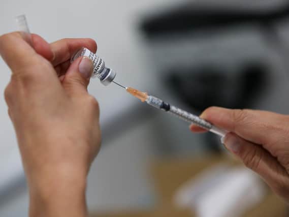 A staff member prepares a Pfizer vaccination. Photo by Lisa Maree Williams/Getty Images.