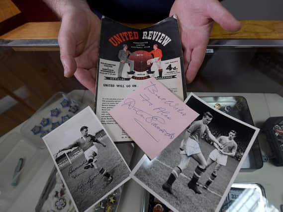 The programme of Manchester United v Sheffield Wednesday the first match after the Munich Air Disaster. Also pictured is a signature from Busby babe Duncan Edwards, and signed photographs of Bobby Charlton and Roger Byrne