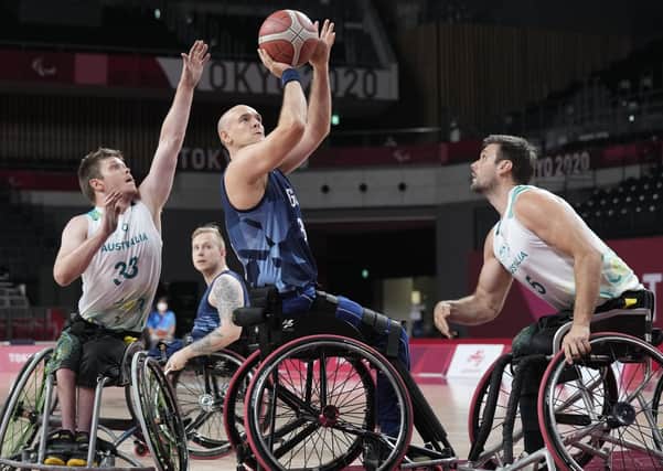 Britain's Ian Sagar tries to score against Australia's defense during a wheelchair basketball men's preliminary round match at the Tokyo 2020 Paralympic Games, Monday, Aug. 30, 2021, in Tokyo, Japan. (AP Photo/Shuji Kajiyama)
