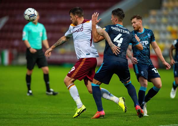 Squeezed out: Andy Cook of Bradford City, left, and Lewis Montsma of Lincoln City challenge for the ball during last night’s Papa John’s Trophy clash at Valley Parade. The Bantams lost 3-0 to the League One side. (Picture: Bruce Rollinson)