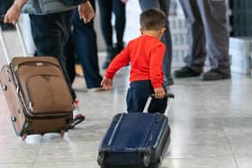 A young boy pulls a suitcase as refugees arrive from Afghanistan at Heathrow Airport, London. Picture: PA