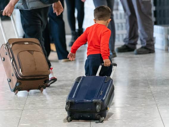 A young boy pulls a suitcase as refugees arrive from Afghanistan at Heathrow Airport, London. Picture: PA