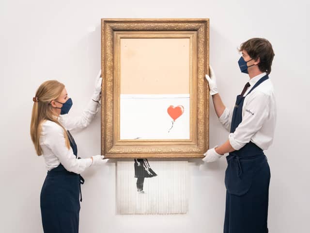 Art handlers at Sotheby's auction house with Banksy's 'Love is in the Bin'