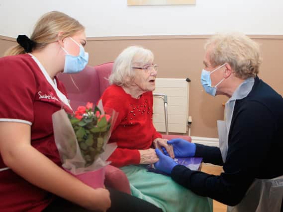 Mike Padgham (right) visits his 93-year-old mother Phyllis Padgham (centre) with Activities Assistant Charlotte Henderson (left) at St Cecilia's Nursing Home in Scarborough, North Yorkshire in March. Picture: Danny Lawson/PA Wire