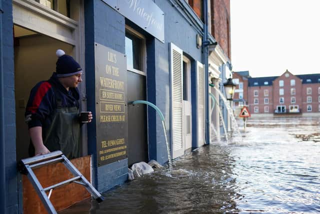 A man looks out over the flood defences at a business premises as the River Ouse in York floods as rain and recent melting snow raise river levels on January 21, 2021. (Photo by Ian Forsyth/Getty Images)