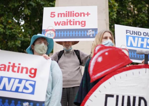 People take part in a protest outside Parliament in central London, calling on the government to tackle NHS waiting lists.