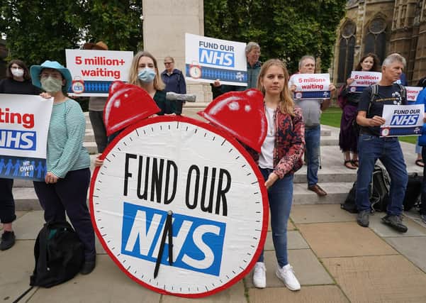 People take part in a protest outside Parliament in central London, calling on the Government to tackle NHS waiting lists.