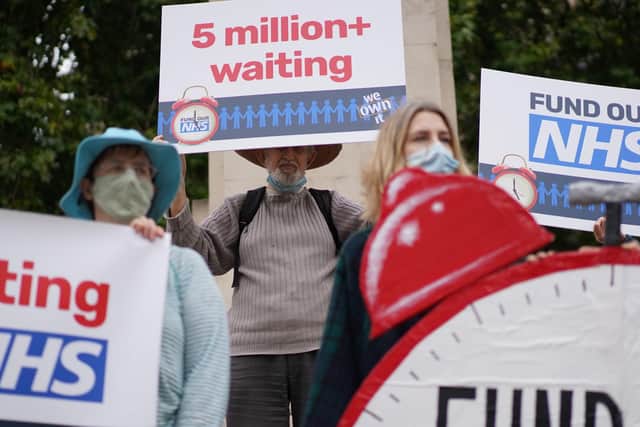 People take part in a protest outside Parliament in central London, calling on the Government to tackle NHS waiting lists.