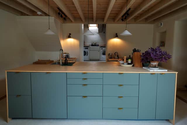 The clever kitchen island with lots of storage was designed by Tom and made from back-to-back Ikea units fitted with brass handles and topped with a ply work surface.