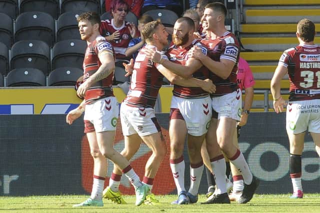 Put it there: Wigan's Jake Bibby is congratulated on scoring a try against Hull FC. Picture by Dean Atkins/SWpix.com