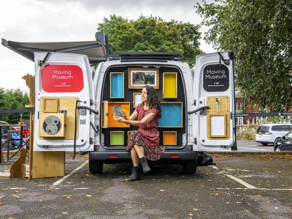 Mina Hayati community engagement officer pictured with a miner's lunchbox by the empty display cabinets in the back of the van of the Moving Museum. Picture Tony Johnson