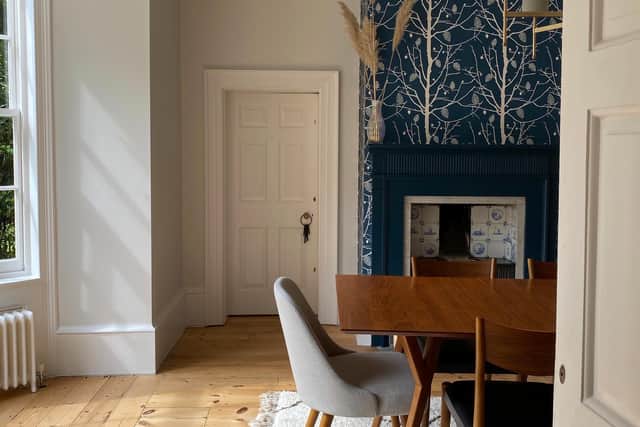 The dining room has a table from West Elm, while the wallpaper on the chimney breast is Family Tree by Ferm Living to match with the Delft tiles in the original fireplace