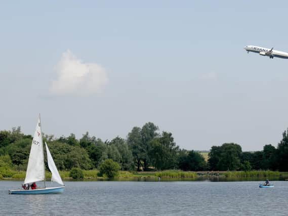 A plane passes by Yeadon Tarn after taking off from Leeds Bradford Airport. Picture: Gary Longbottom