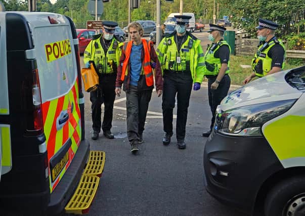 Officers lead a protester to a police van at a slip road at Junction 18 of the M25, near Rickmansworth, where climate protesters carried out a further action after demonstrations which took place last week across junctions in Kent, Essex, Hertfordshire and Surrey.
