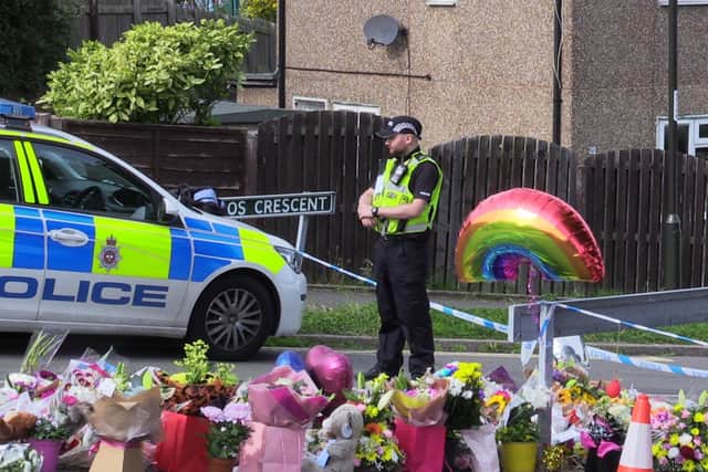 Police at the scene in Killamarsh, where flowers and tributes have been laid