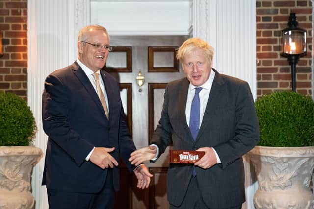 Prime Minister Boris Johnson is given a packet of the Australian snack, Tim Tams as he is greeted by his Australian counterpart, Scott Morrison in Washington DC,