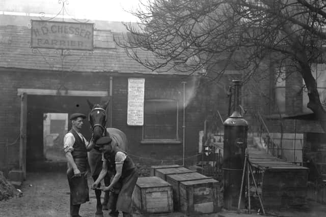 1926:  Blacksmiths at work at their smithy, which also has a petrol pump, at Wood Green.  (Photo by Fox Photos/Getty Images)