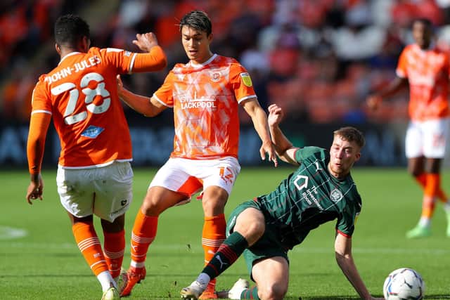 Blackpool's Kenny Dougall (centre) and Barnsley's Jasper Moon (right) battle for the ball at Bloomfield Road Picture: Tim Markland/PA