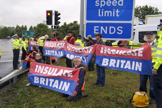 Members of Insulate Britain occupying a roundabout leading from the M25 motorway