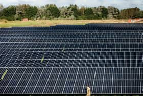 Major David Owen walks through a field of solar panels at the opening of the British Army's first ever solar farm