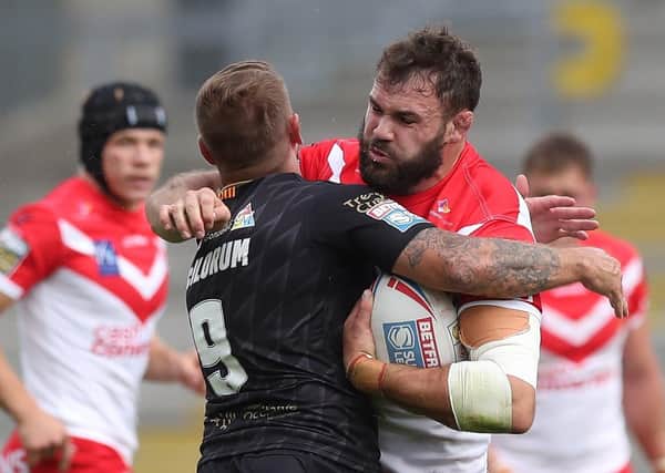 St Helens' Alex Walmsley is tackled by Catalan Dragons' Michael Mcilorum.
