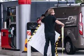 An employee removes a no fuel sign from the forecourt of a petrol station in Leeds on Tuesday.