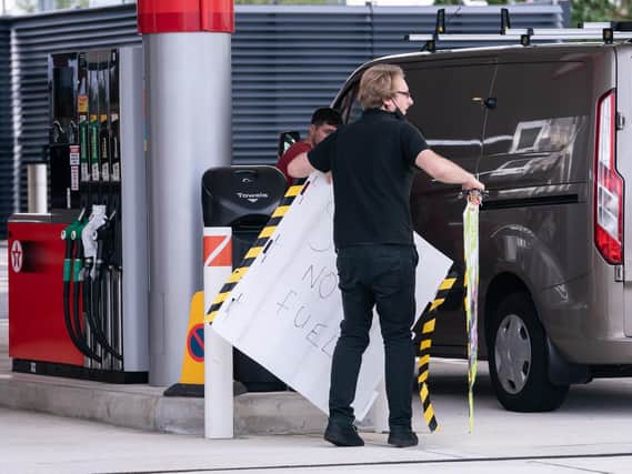 An employee removes a no fuel sign from the forecourt of a petrol station in Leeds on Tuesday.