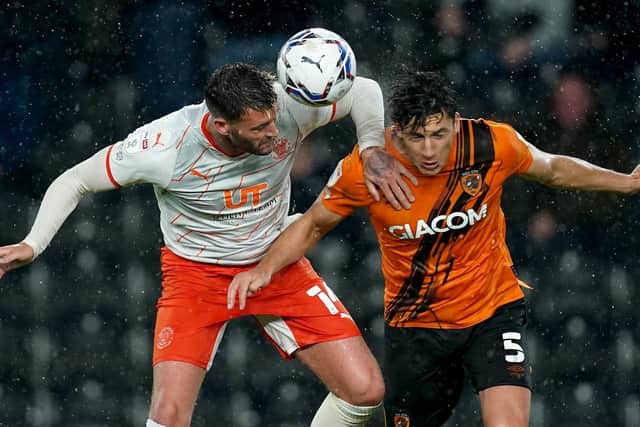 Up for the fight: Alfie Jones, right, in action against Blackpool on Tuesday as Hull battled back to earna vital point. (Picture: PA)