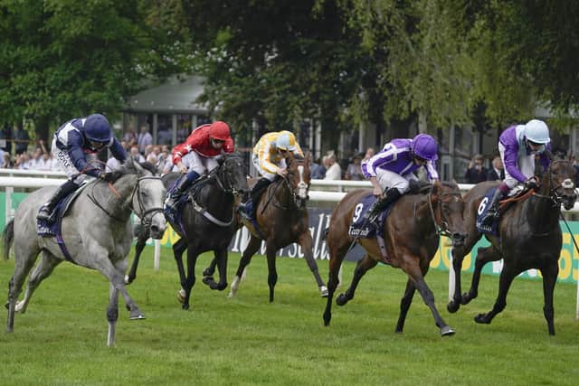 Sean Levey and Snow Lantern (left) swoop late to win the Falmouth Stakes at Newmarket.