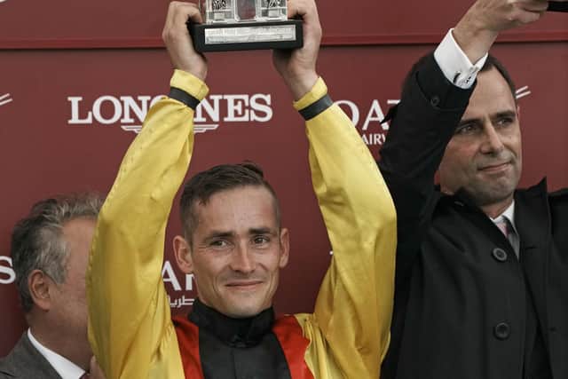 Jockey Rene Piechulek holds his trophy after winning the Prix de l'Arc de Triomphe horse race on Torquator Tasso.